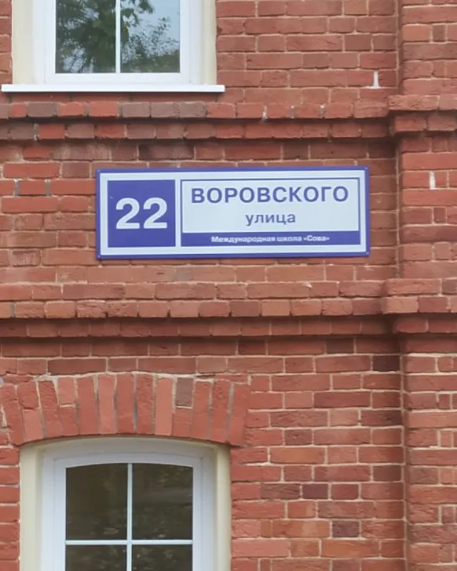 Адресная табличка «Воровского, 22» на кирпичном фасаде